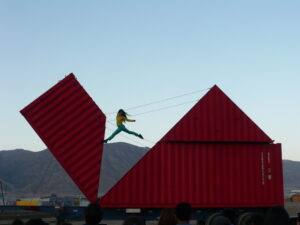 Silhouette d'une danseuse suspendue dans les airs et d'un container ouvert dans une forme d'origami